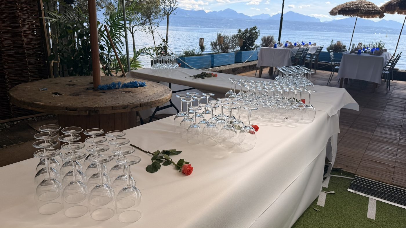 Mise en place élégante pour un banquet, verres et rose sur nappe blanche