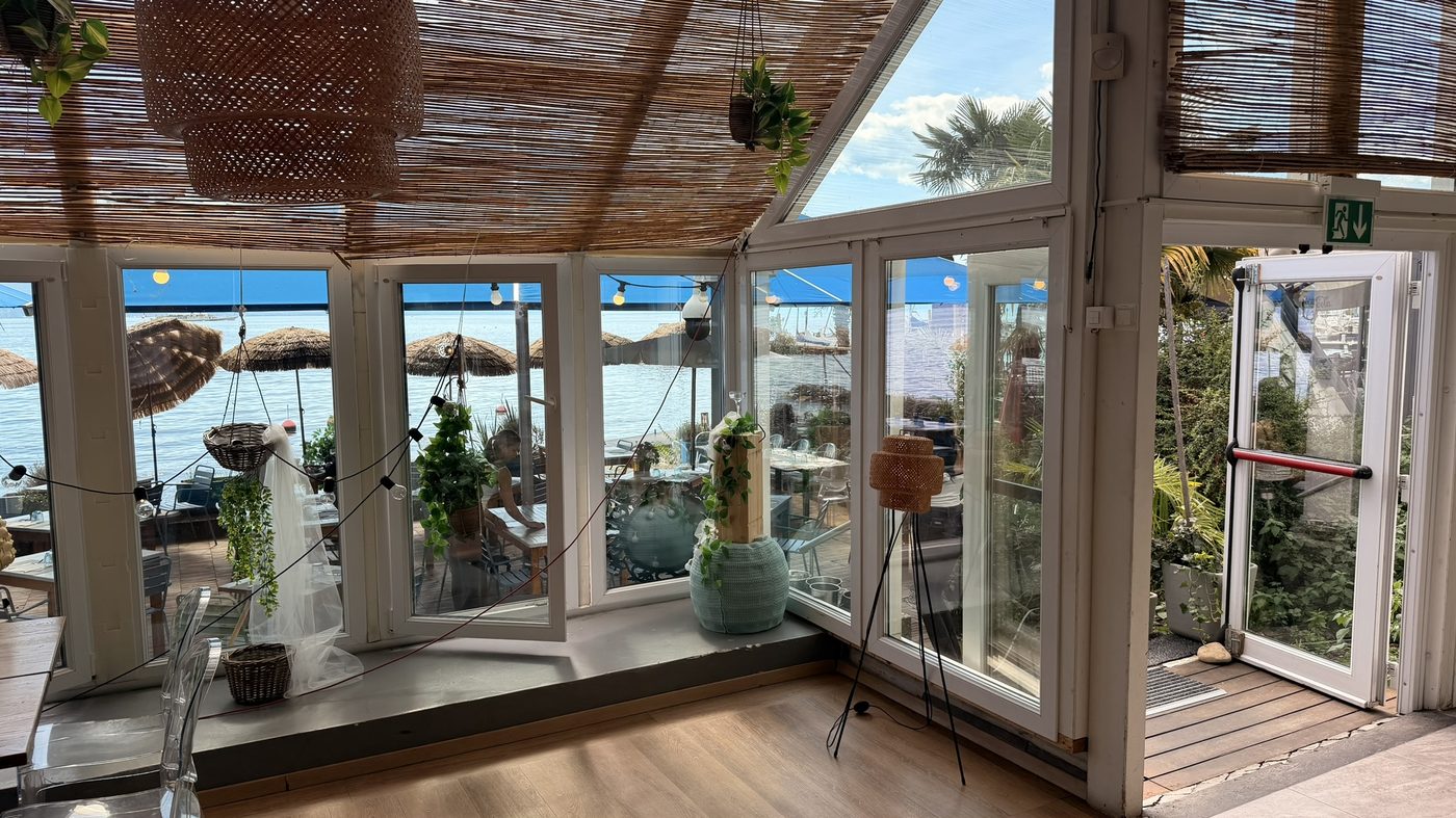 Véranda lumineuse du restaurant Il Lido, vue sur le lac Léman